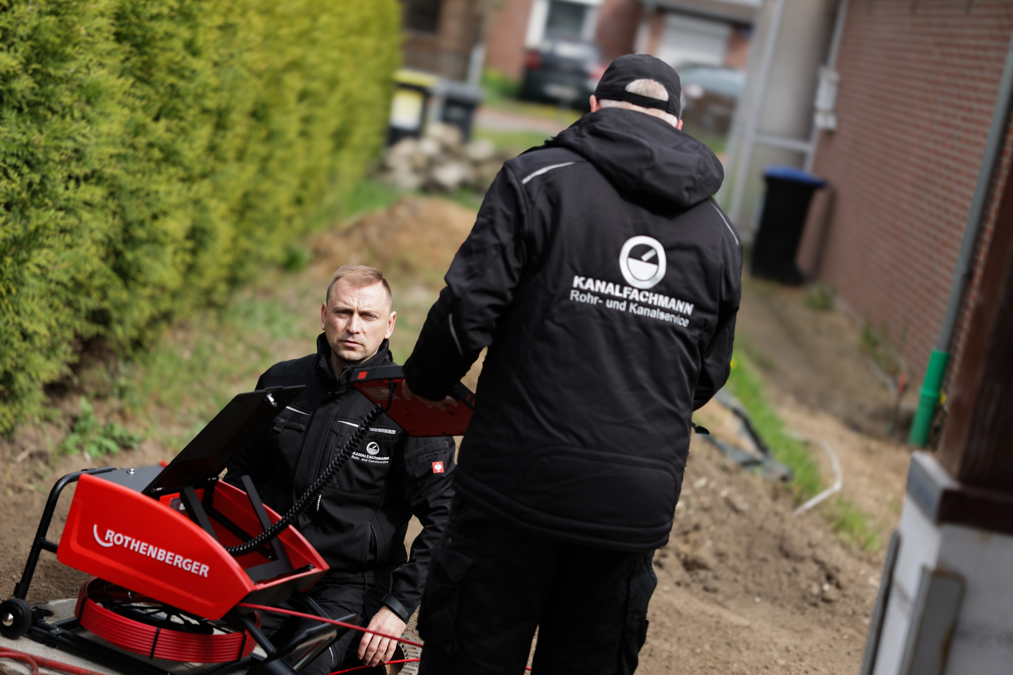 Zwei Kanalfachmann Techniker besprechen den Einsatzplan neben Rothenberger-Ausrüstung
